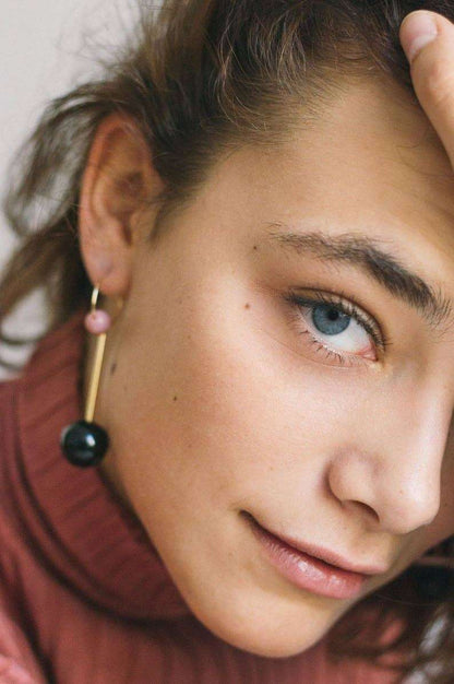Roze rhodoniet oorbel met goudkleurige oorbel en zwart en roze kralen