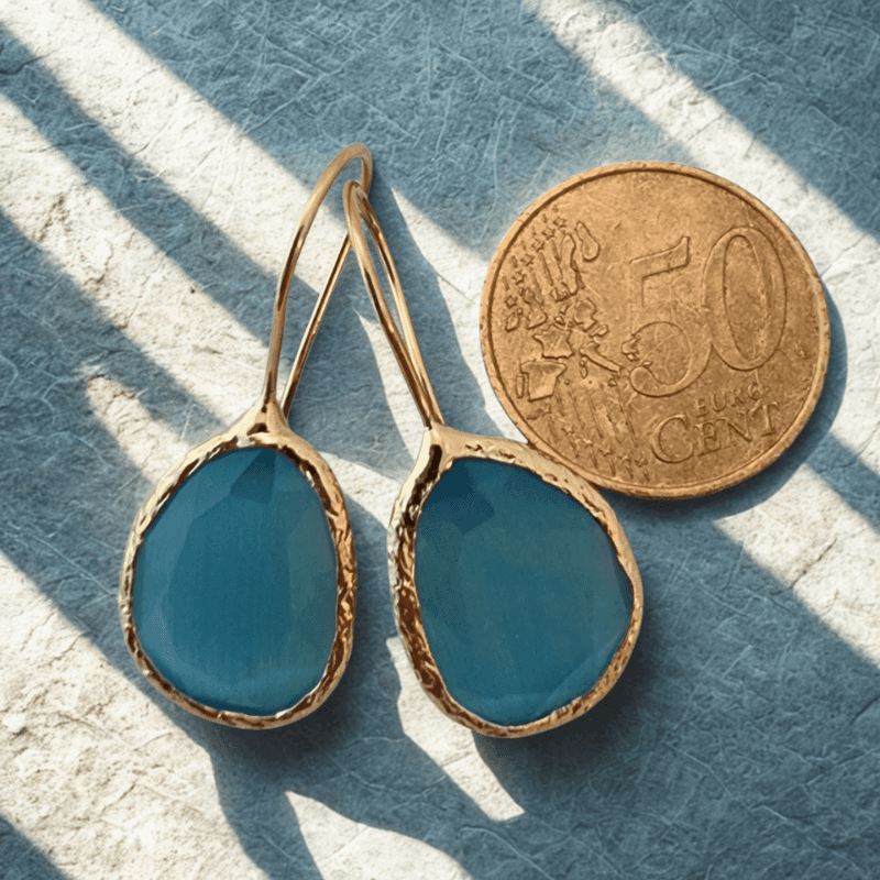 Gouden oorbellen met blauwe cateye stenen en handgemaakt design