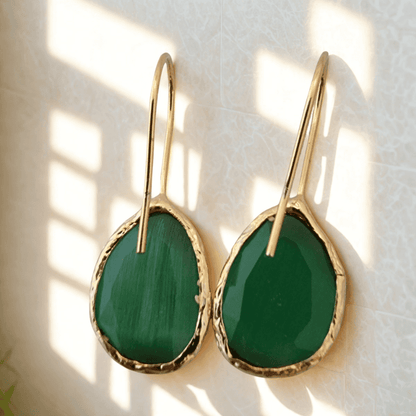 Gouden oorbellen met groene cateye stenen en asymmetrisch ontwerp