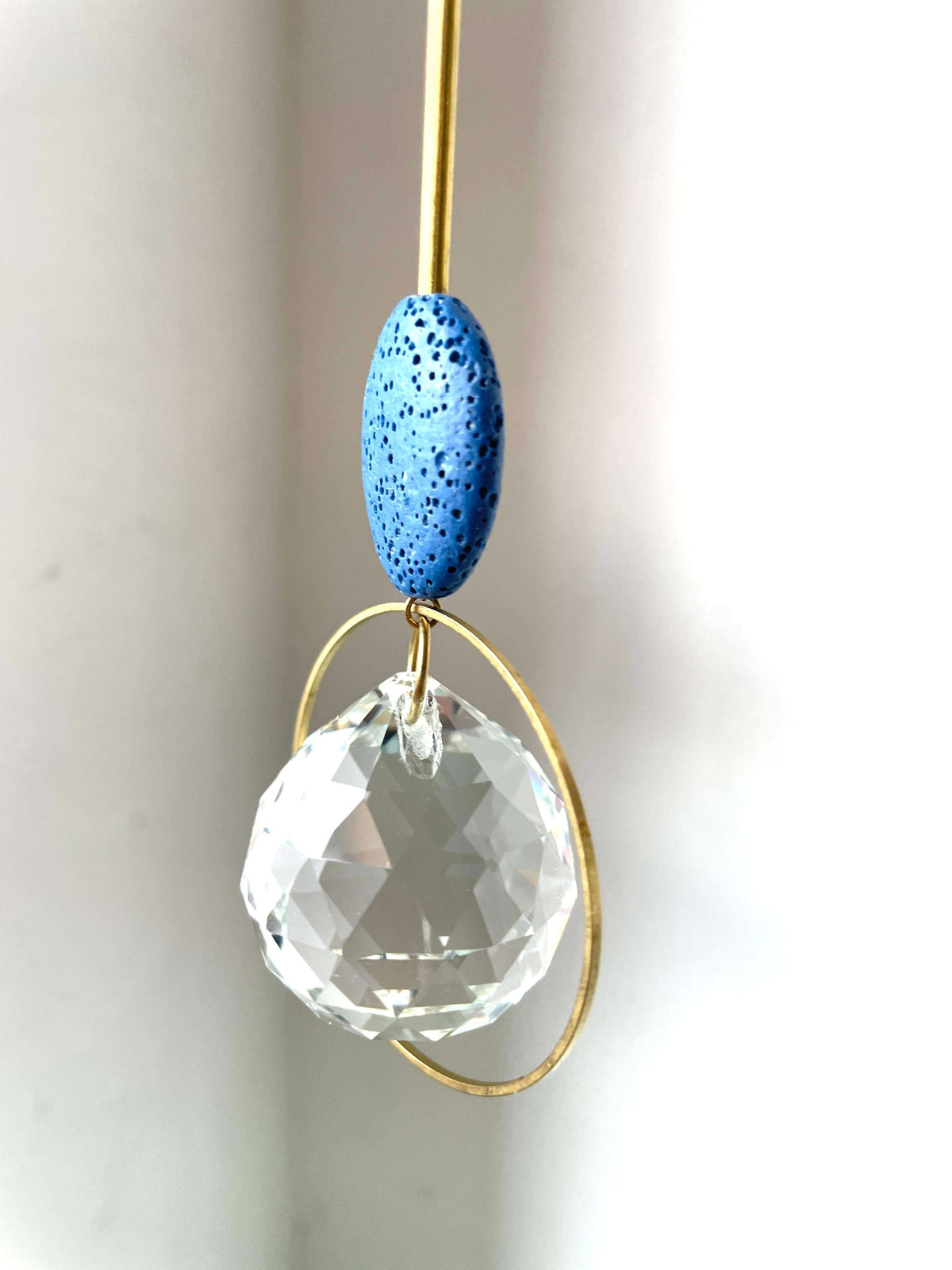 Kleurrijke zonnevanger met kristallen bol en blauwe keramiek, spirituele decoratie voor raam