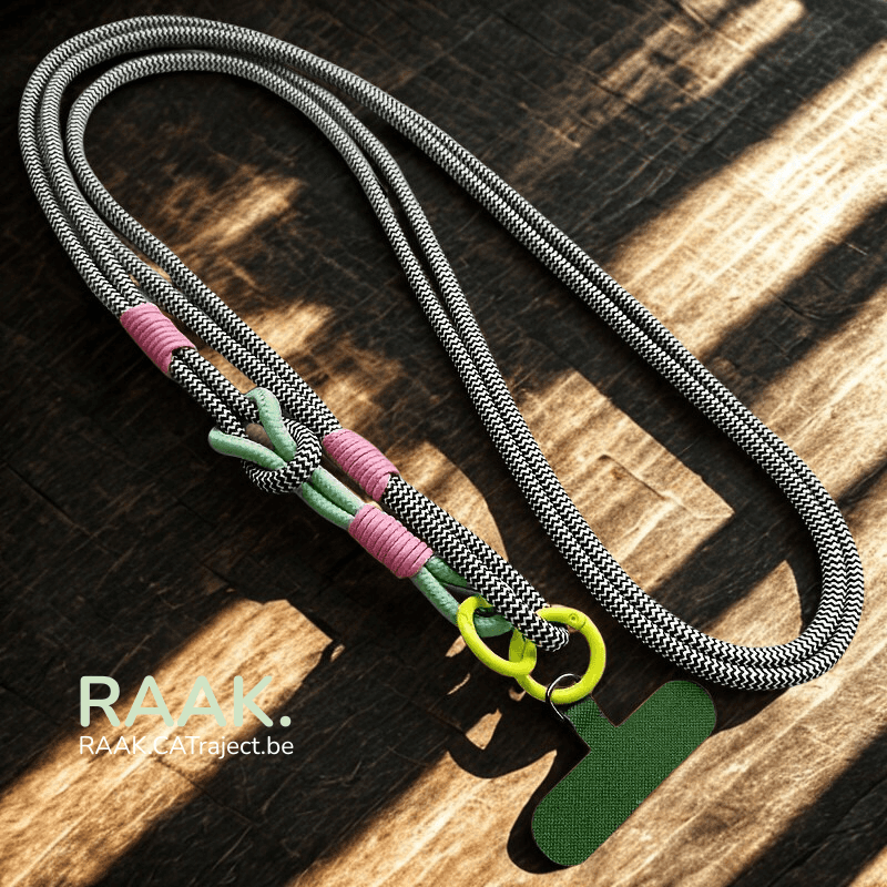 Zwart-witte sportieve lanyard met kleurrijke details en telefoonclip op houten oppervlak