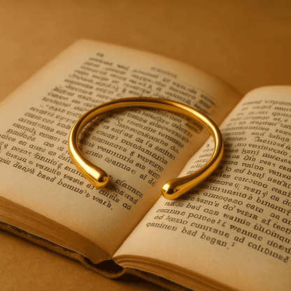 Gouden verstelbare armband op open boek