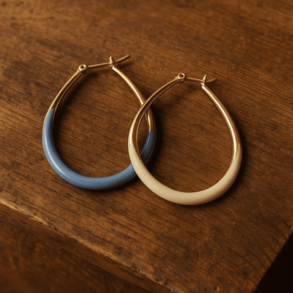 Gouden en blauw emaille oorbellen op witte achtergrond
