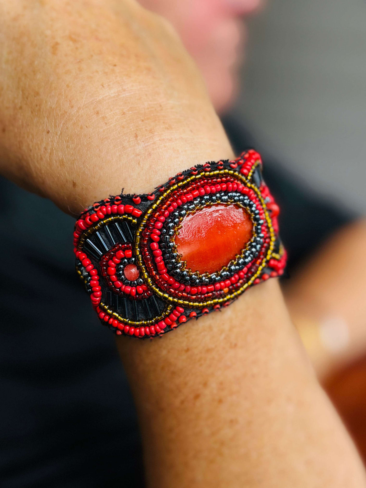 Kleurrijke handgemaakte kralenarmband met grote oranje steen