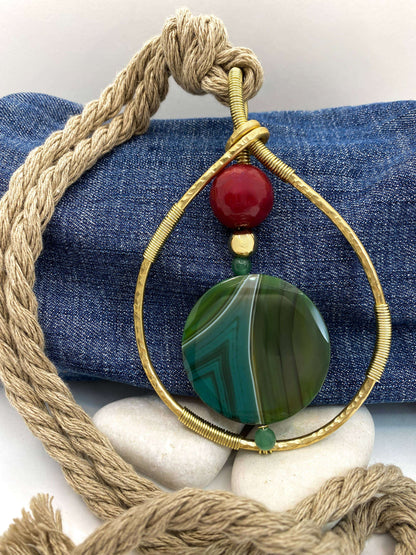 Close-up van de RAAK.Halsketting ERISA met grote groene steen en gouden metalen frame