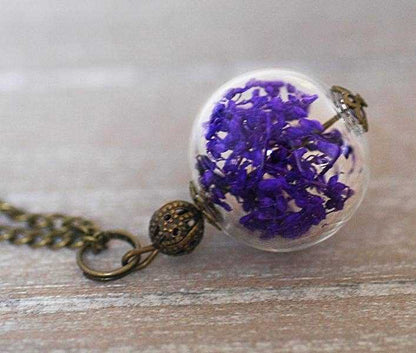 Droogbloemen halsketting met glazen bol en bronzen ketting